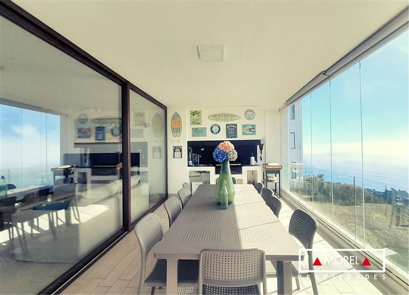 Orientación norponiente con maravillosa vista panorámica al mar. Hall de acceso, living, comedor con chimenea empotrada 